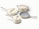 Caraway ceramic cookware set in Cream with four pans, three matching lids.