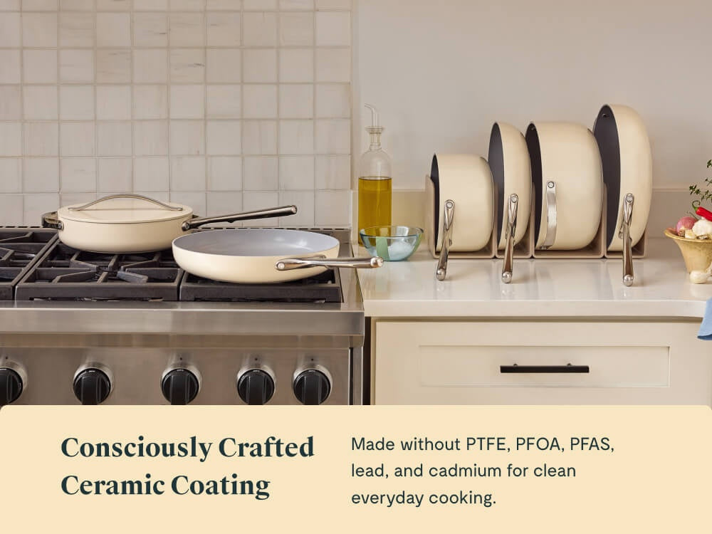 Caraway Cream ceramic cookware on a stove and in organizers; ceramic coating made without PTFE, PFOA, PFAS, lead, or cadmium.