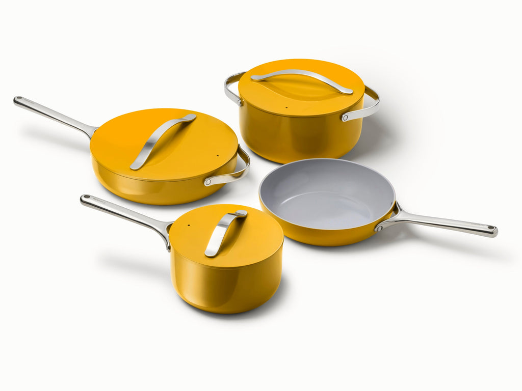 Caraway ceramic cookware set in Marigold with four pans, three matching lids.