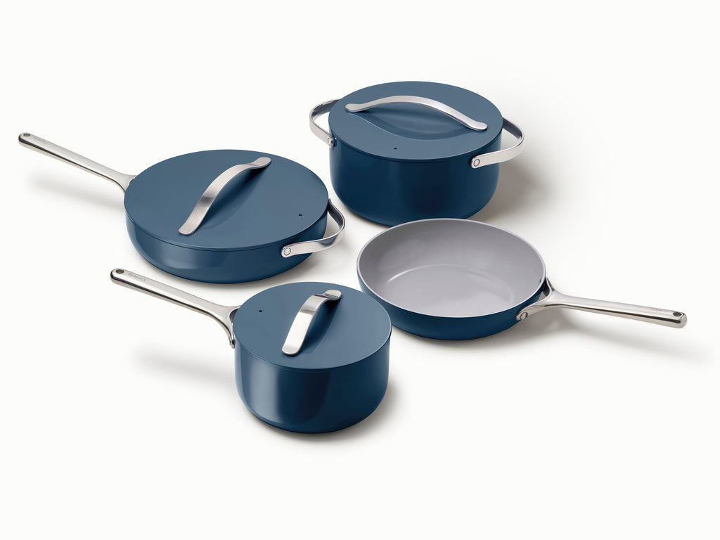 Caraway ceramic cookware set in Navy with four pans, three matching lids.