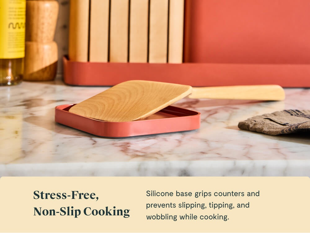 Caraway perracotta spoon rest holding a wooden spatula beside a utensil organizer.