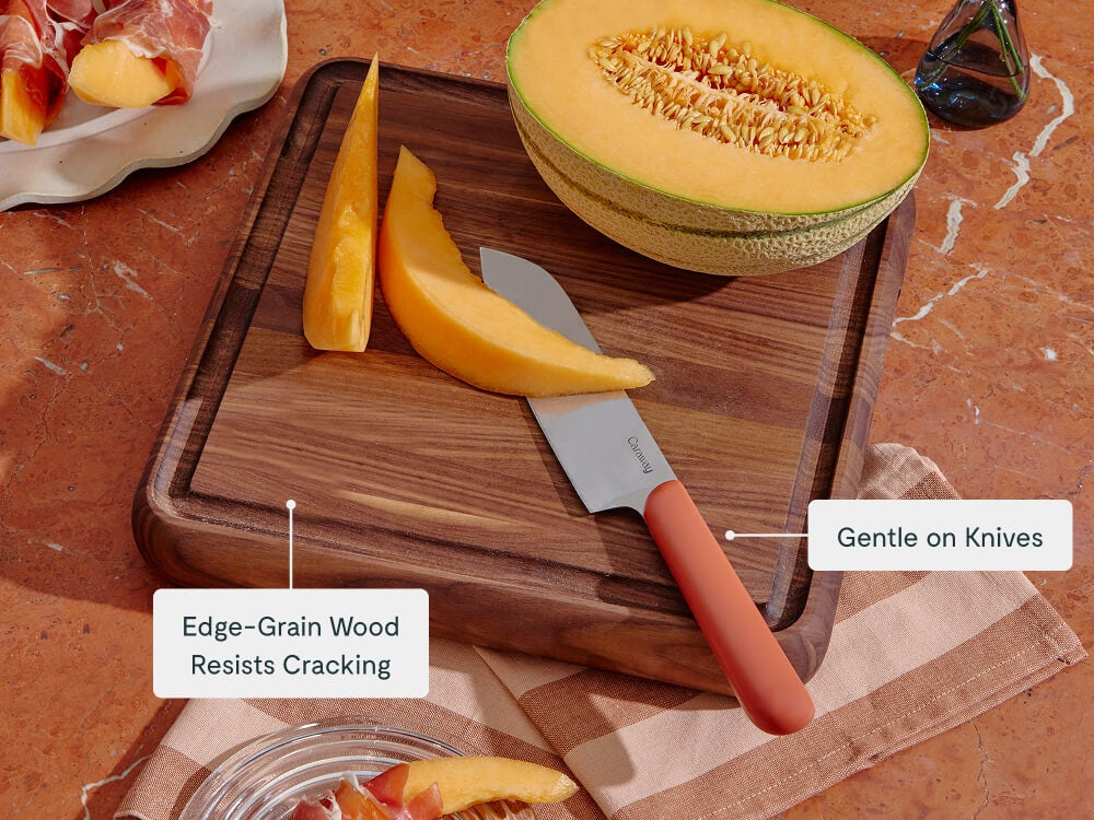 Caraway walnut square butcher block holding sliced melon and a kitchen knife.