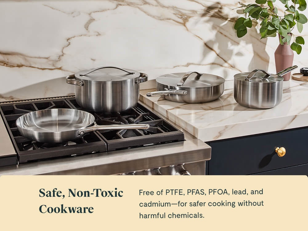 Caraway stainless steel cookware arranged on a stove and kitchen counter.