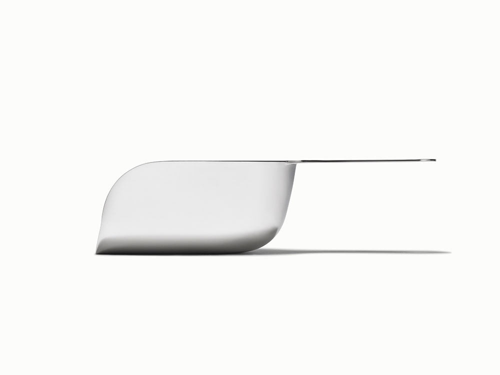 Caraway side view of a stainless steel scoop with a long flat handle.