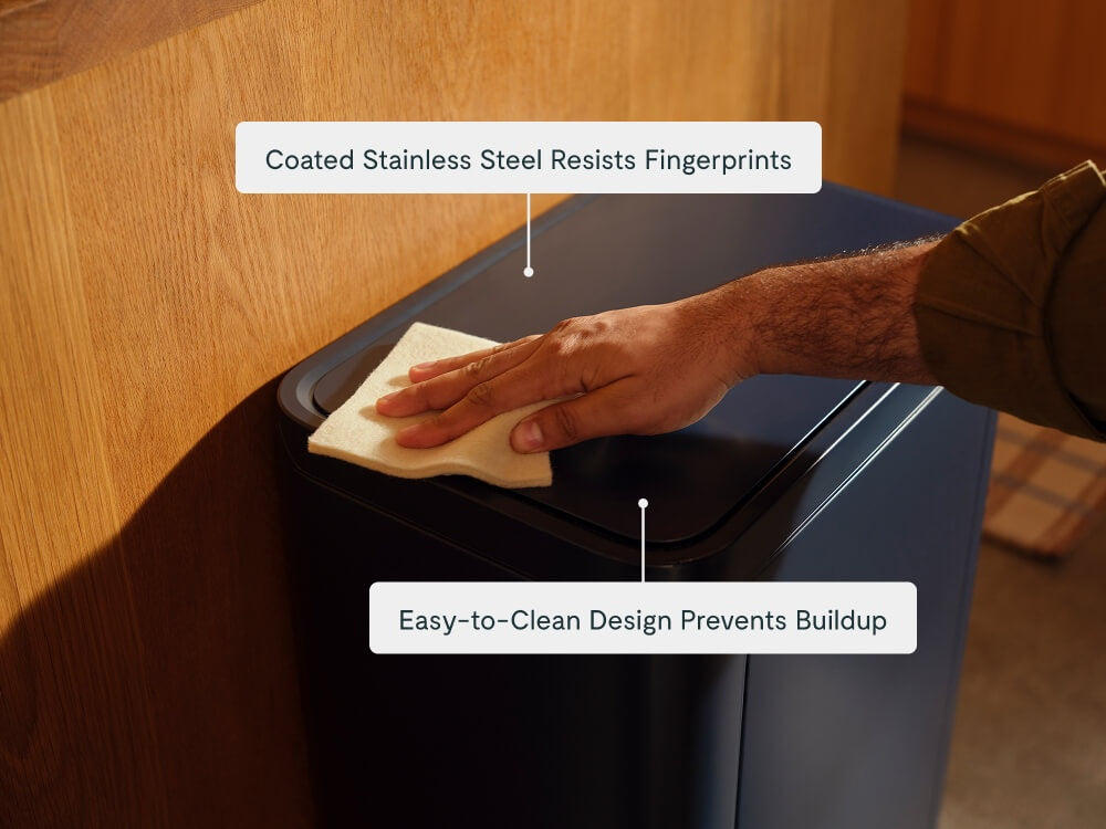 Hand wiping the lid of a Navy trash can with a cloth.