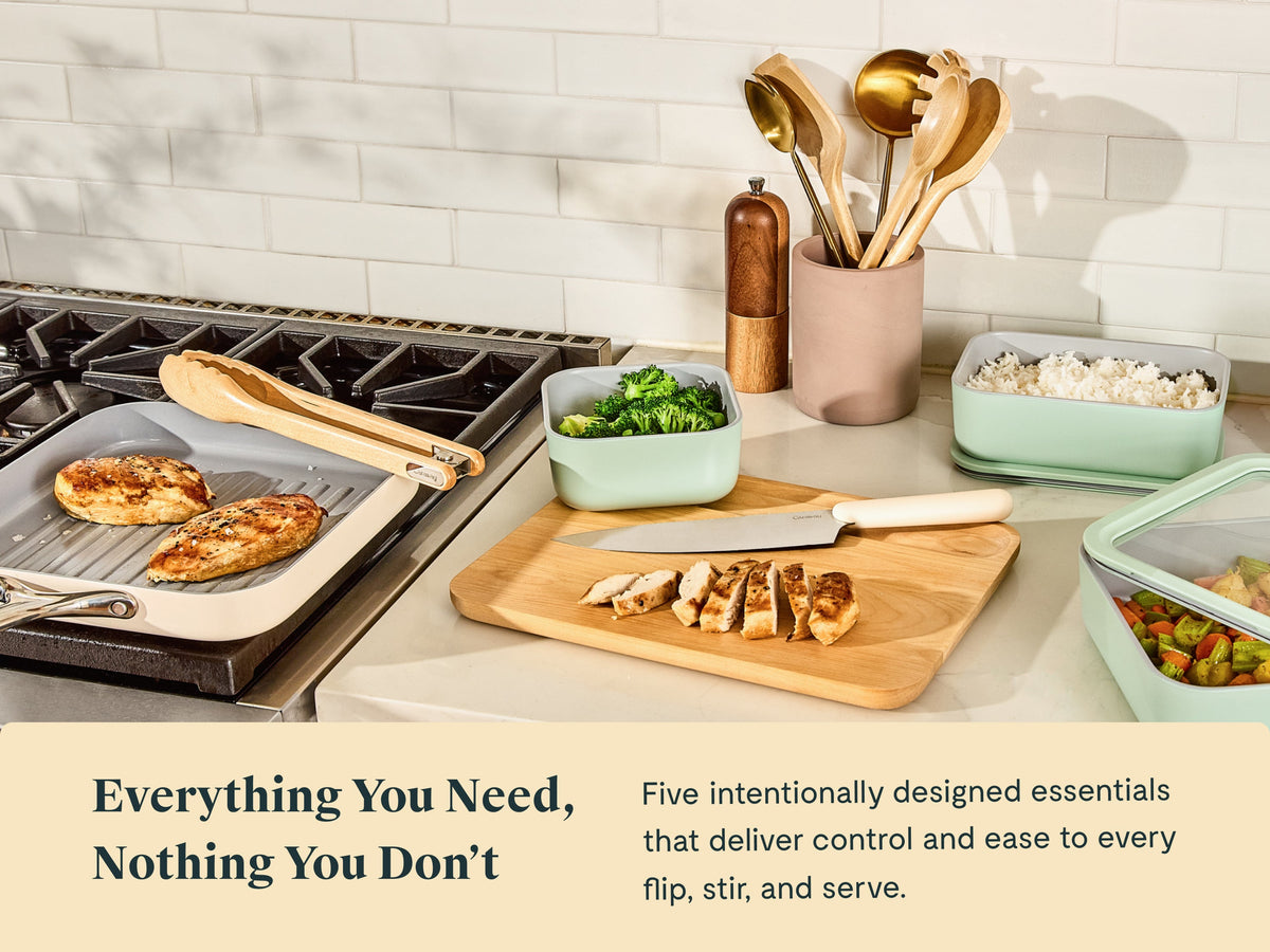 Caraway wooden utensils on a kitchen counter beside food storage containers and bakeware.